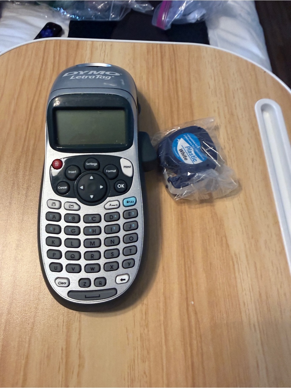 Dymo handheld label maker in silver and black with white tape